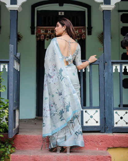 Light pastel blue linen saree with floral print, tassels on the edges, and an attached matching blouse piece.